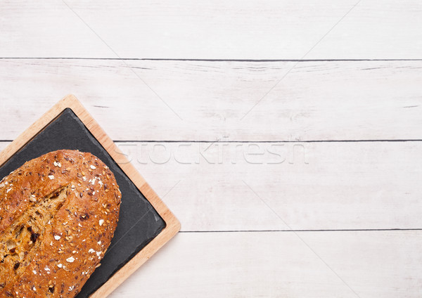 Freshly baked  bread with oats on wooden board Stock photo © DenisMArt