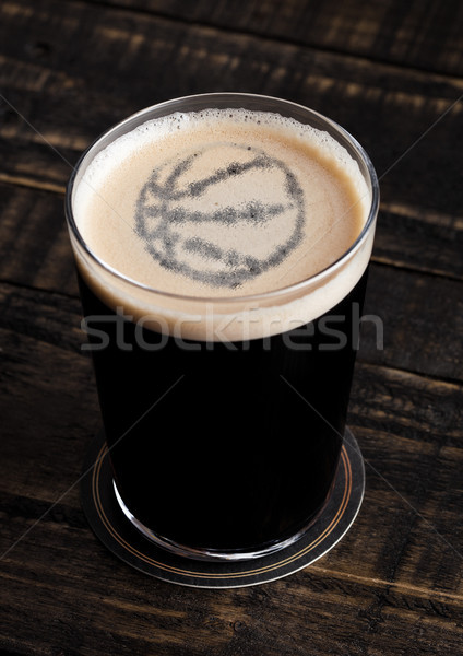 Glass of stout beer top with basketball shape Stock photo © DenisMArt