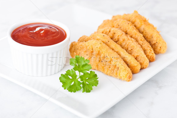 Fried chicken dippers on chopping board with sauce Stock photo © DenisMArt