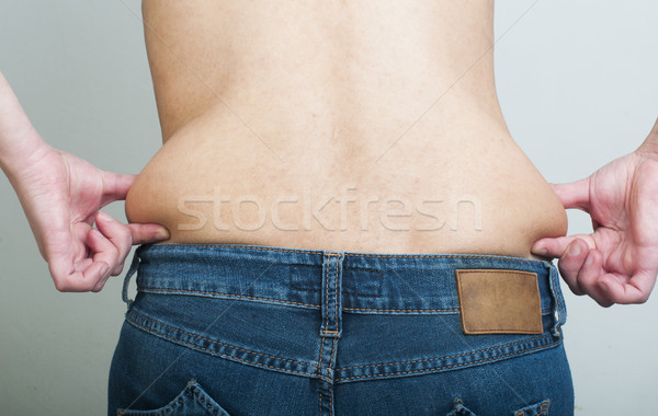 Woman pinching fat from her waist Stock photo © deyangeorgiev