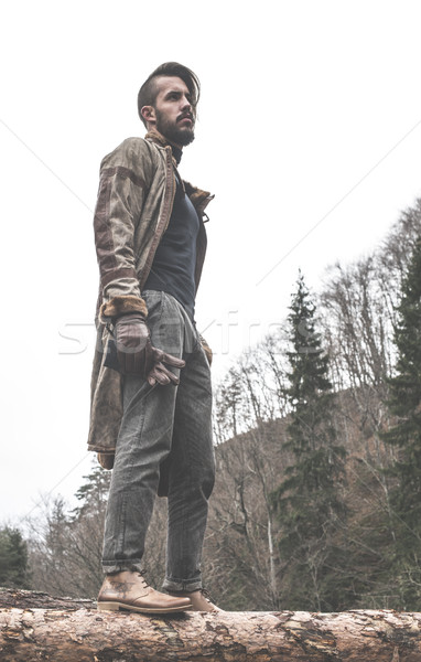 Young men on logs in the forest. Stock photo © deyangeorgiev