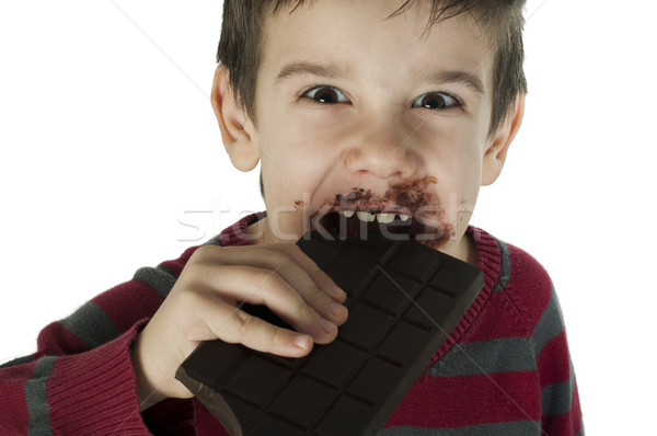 Stock photo: Smiling little boy eating chocolate