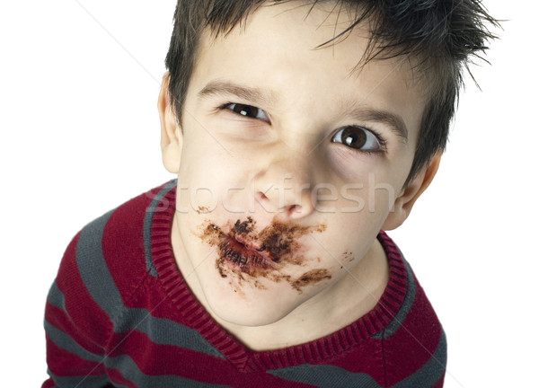 Stock photo: Smiling little boy eating chocolate