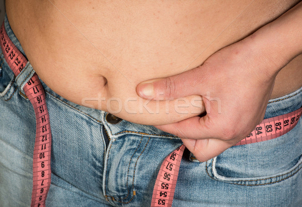 Woman showing fat belly Stock photo © deyangeorgiev