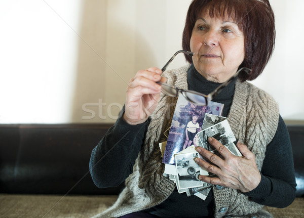 Idős nő öreg fotók néz szomorúság Stock fotó © deyangeorgiev