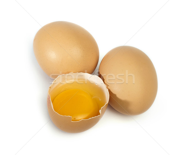 Tree whole eggs and another broken in half raw egg Stock photo © deyangeorgiev