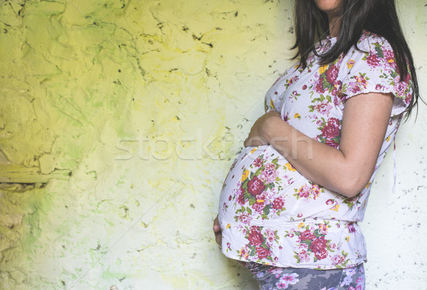 Pregnant women in front of old colored wall. Stock photo © deyangeorgiev