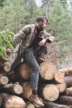 Young man and dog on logs in the forest Stock photo © deyangeorgiev