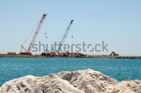 Building a dike. Cranes and excavator put stones Stock photo © deyangeorgiev