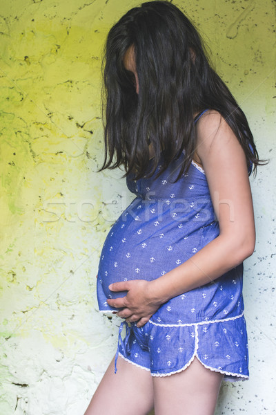 Pregnant women in front of old colored wall. Stock photo © deyangeorgiev