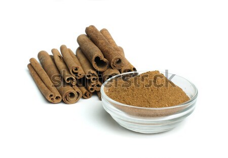 Powdered cinnamon in bowl and cinnamon sticks Stock photo © deyangeorgiev