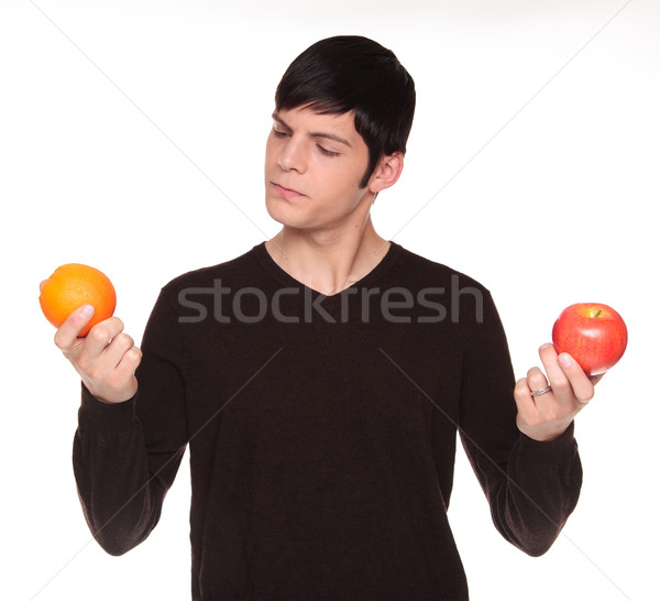Caucasian man comparing apple to orange Stock photo © dgilder