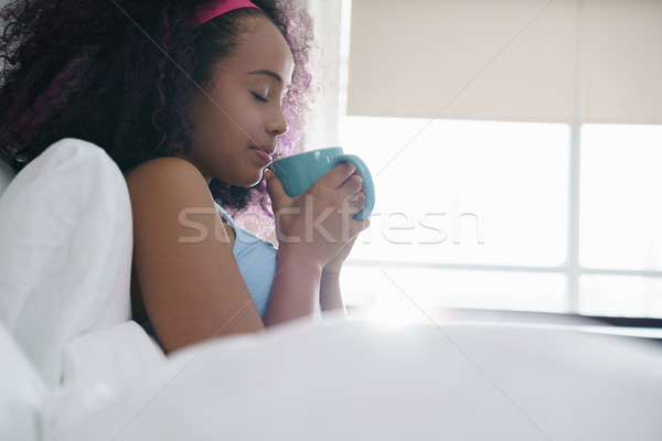 Black Woman Drinking Coffee In Bed Smiling Stock photo © diego_cervo