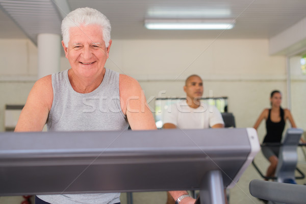 Stock photo: senior man exercising in wellness club