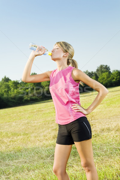 Jogging jeune femme potable une bouteille d'eau extérieur espace de copie Photo stock © diego_cervo