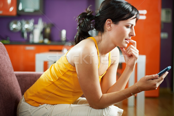 Ideges nő tart mobiltelefon felnőtt kanapé Stock fotó © diego_cervo