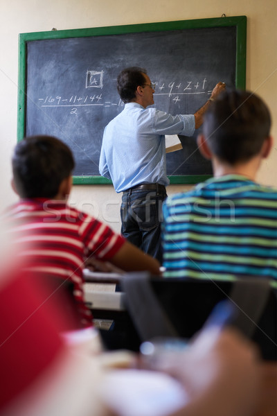 Middle Aged Teacher At Blackboard Giving Class Of Math Stock photo © diego_cervo