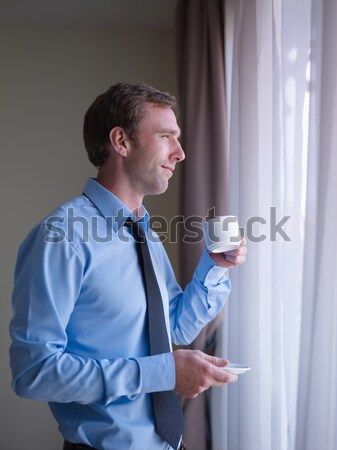 Businessman drinking coffee and looking out of window Stock photo © diego_cervo