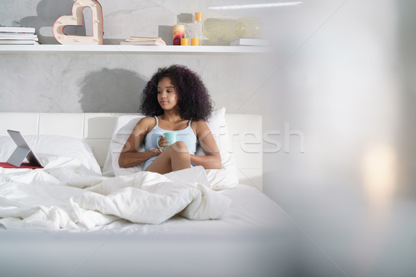 Woman Drinking Coffee Watching Movie In Bed on Sunday Stock photo © diego_cervo