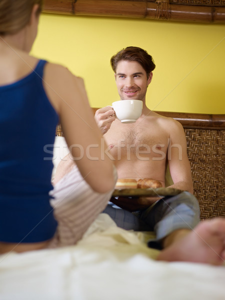 Stock photo: young couple having breakfast on bed