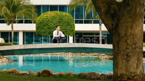 Businessman Meditating Doing Yoga Outside Office Building Stock photo © diego_cervo