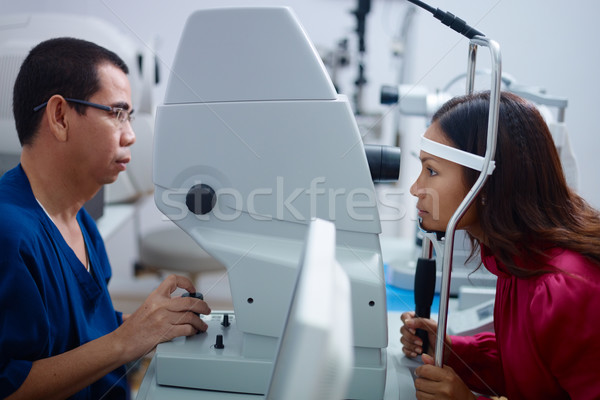 Eyesight exam in clinic with Asian doctor and female patient Stock photo © diego_cervo