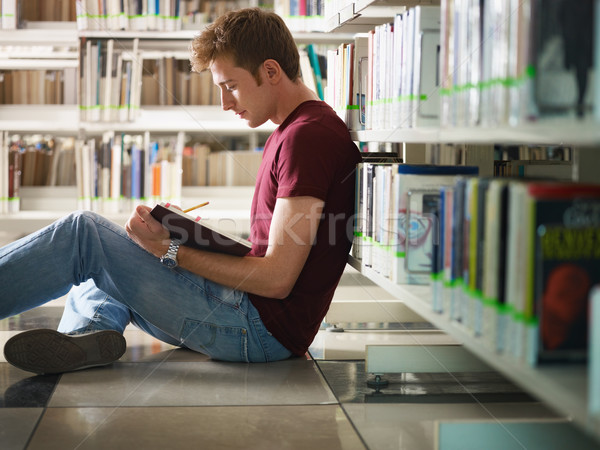 Fickó tanul könyvtár férfi főiskolai hallgató ül Stock fotó © diego_cervo