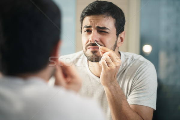 Handsome Man Trimming Nose Hair In Bathroom Stock photo © diego_cervo