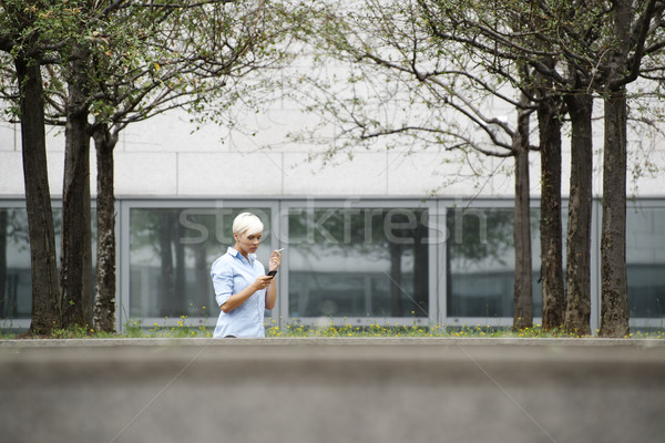 business woman smoking cigarette and typing sms on phone  Stock photo © diego_cervo