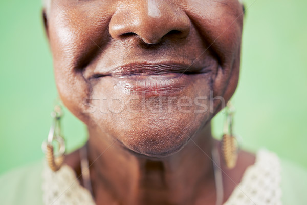Closeup of old woman mouth against green background Stock photo © diego_cervo