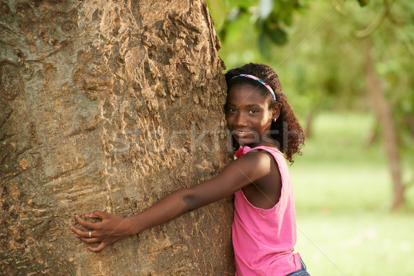 Portrait of black ecologist girl hugging tree and smiling Stock photo © diego_cervo
