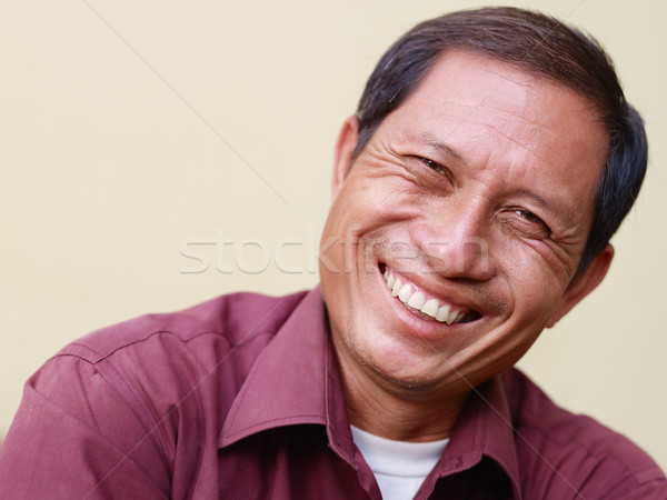 Stock photo: Happy mature Asian man smiling and looking at camera