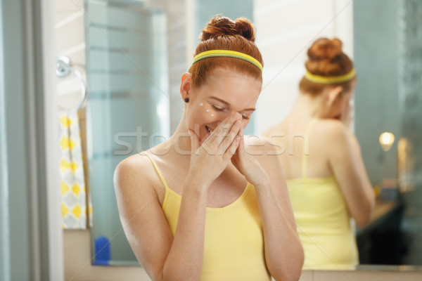 Young Woman Applies Anti Age Cream On Face Smiling Stock photo © diego_cervo
