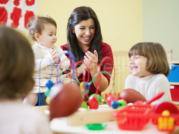 three little girls and female teacher in kindergarten Stock photo © diego_cervo