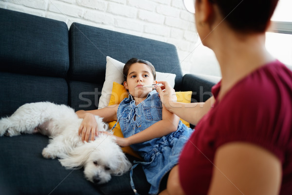 Stock photo: Mother Checking Temperature To Ill Daughter With Thermometer