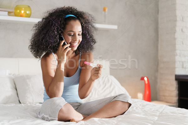 Szczęśliwy czarnej kobiety test ciążowy telefon młodych Zdjęcia stock © diego_cervo