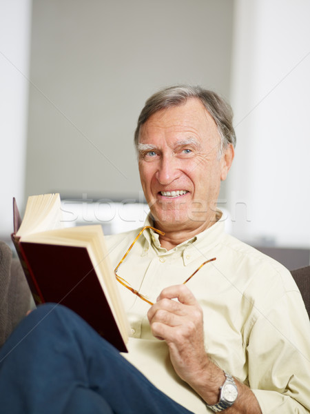 Starszy człowiek czytania książki domu patrząc Zdjęcia stock © diego_cervo