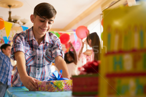 Child Putting Present On Table During Birthday Party At Home Stock photo © diego_cervo