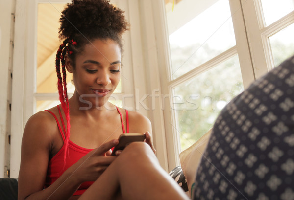 Foto stock: Jovem · mulher · negra · leitura · telefone · mensagem · sorridente