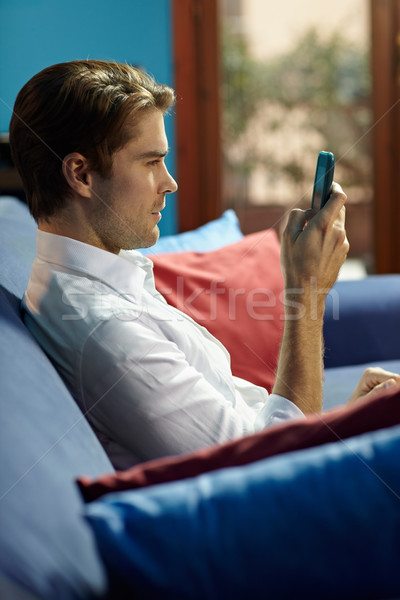 Stockfoto: Man · typen · sms · mobieltje · vergadering · sofa