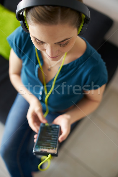 Woman With Green Earphones Listens Podcast Music On Phone Stock photo © diego_cervo