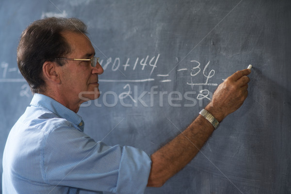 Teacher Writing Math Formulas On Blackboard At High School Stock photo © diego_cervo