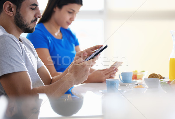 Partners Using Phone While Eating Breakfast Together Stock photo © diego_cervo