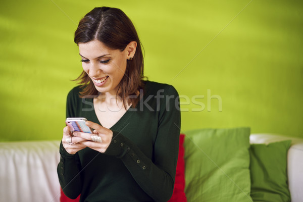 portrait of girl reading sms on smarthphone at home Stock photo © diego_cervo