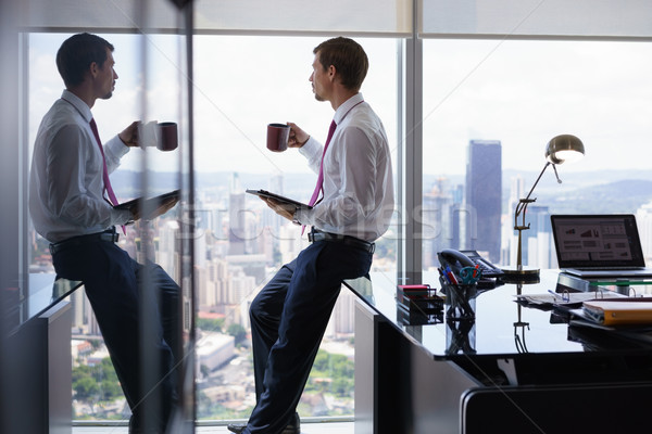 Business Man Drinking Coffe And Reading News On Tablet Stock photo © diego_cervo