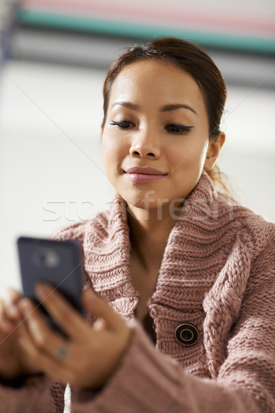 asian girl reading sms on smarthphone Stock photo © diego_cervo