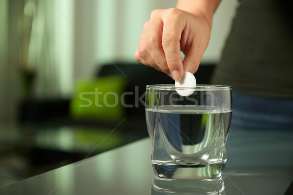 Stock photo: Sick Woman Puts Effervescent Tablet Aspirin In Glass Of Water