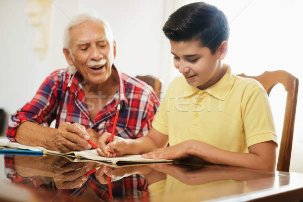 Little Boy Doing School Homework With Old Man At Home Stock photo © diego_cervo