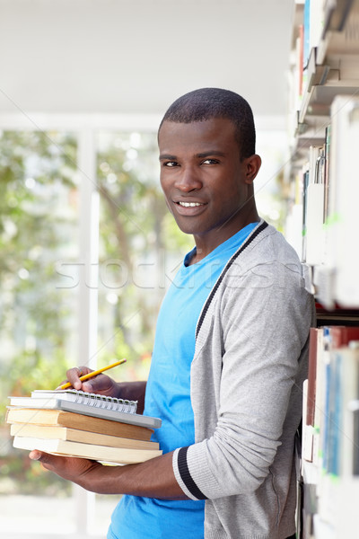 Jonge afrikaanse man glimlachend bibliotheek afro-amerikaanse Stockfoto © diego_cervo