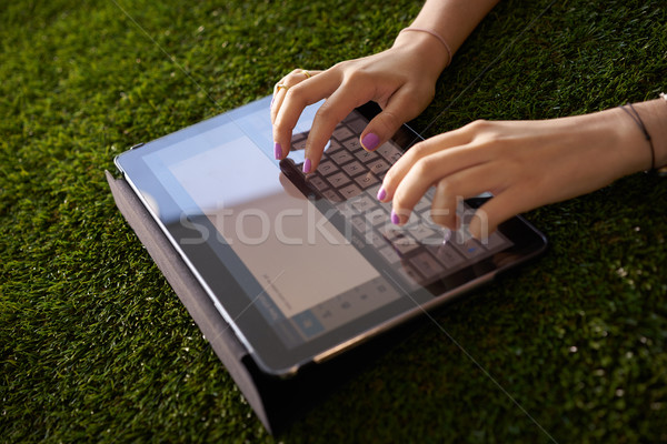 Woman Emailing And Texting With Tablet Computer On Grass Stock photo © diego_cervo